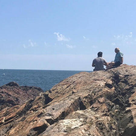 Two people enjoy the rocky seascape in Nahant, Massachusetts.